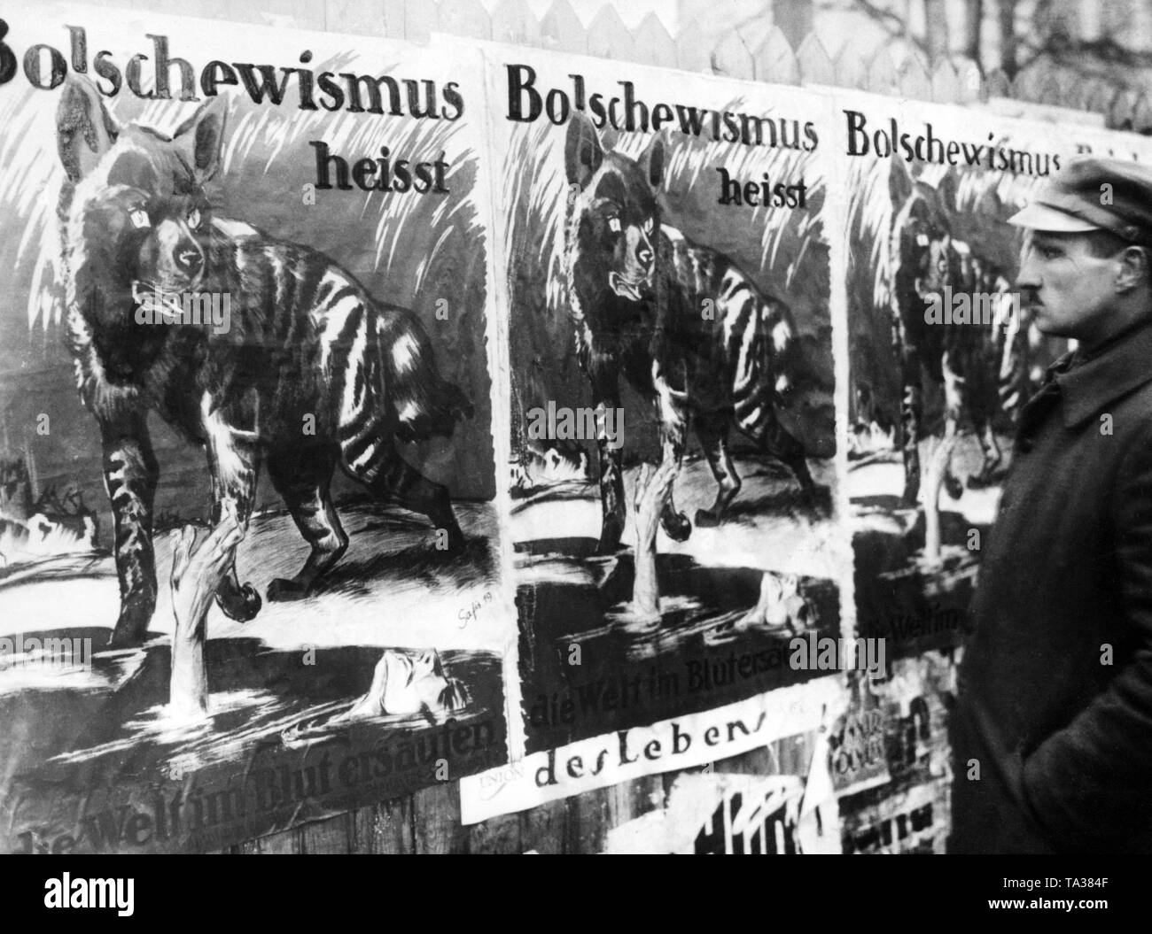 A man looks at a anti-Bolshevik propaganda poster. In the course of the unrest in the spring of 1919, the struggle against Leftist groups was fought by all available means Stock Photo