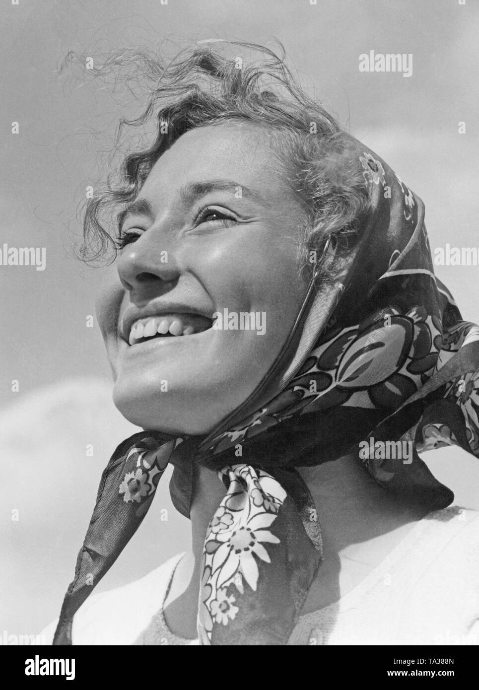 Portrait of a woman (presumably) from the 1930s with a flowered headscarf. Undated photo. Stock Photo