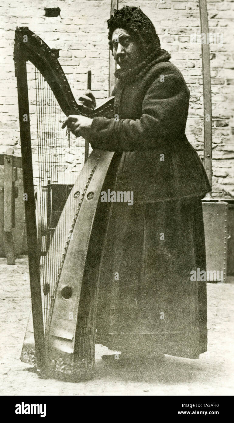 The 'Harfenjule' Luise Nordmann with her harp in a courtyard. Stock Photo