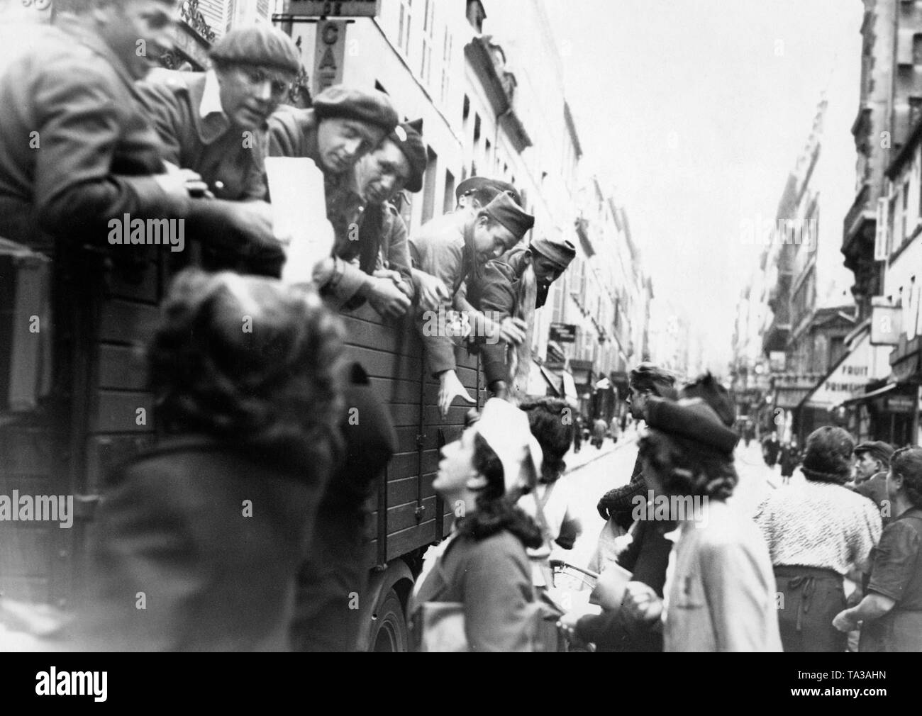 A truck with French soldiers in the Rue des Martyrs in Paris. The soldiers are driven in a German lorry through Paris, which stops here, so that Parisians can supply their compatriots. Stock Photo