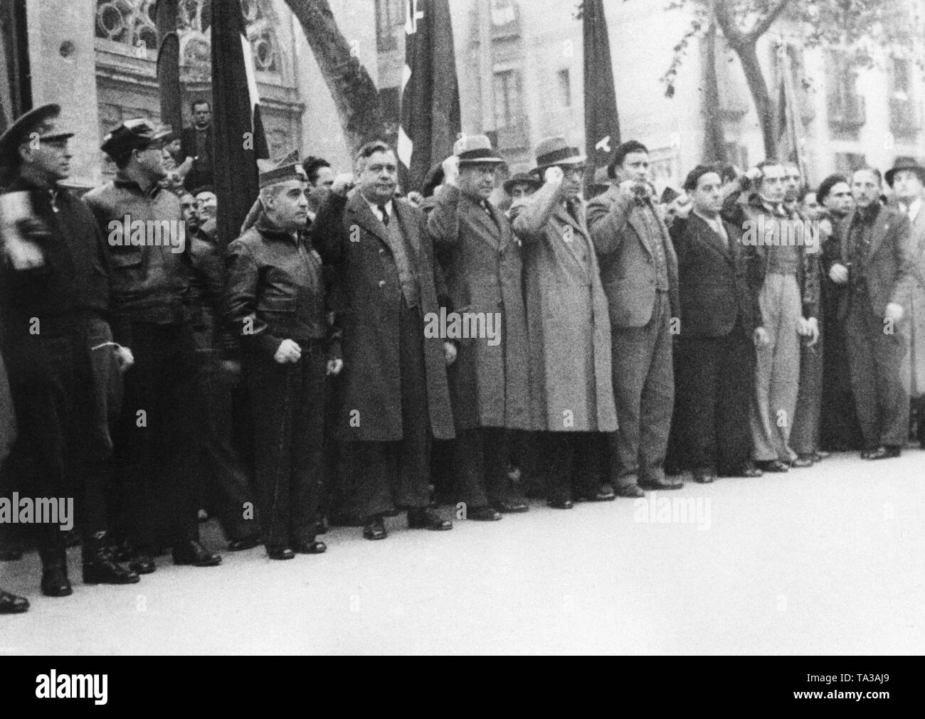 Photo of passers-by who give their last escort to the fallen Republican fighter Hans Beimler during the funeral procession in Barcelona at the beginning of December 1936. The former communist deputy of the German Reichstag and political commissar of the Thaelmann Batallion of the XI. International Brigade was shot dead by Spanish national troops near Moncloa Palace in Madrid on December 1, 1936. Stock Photo