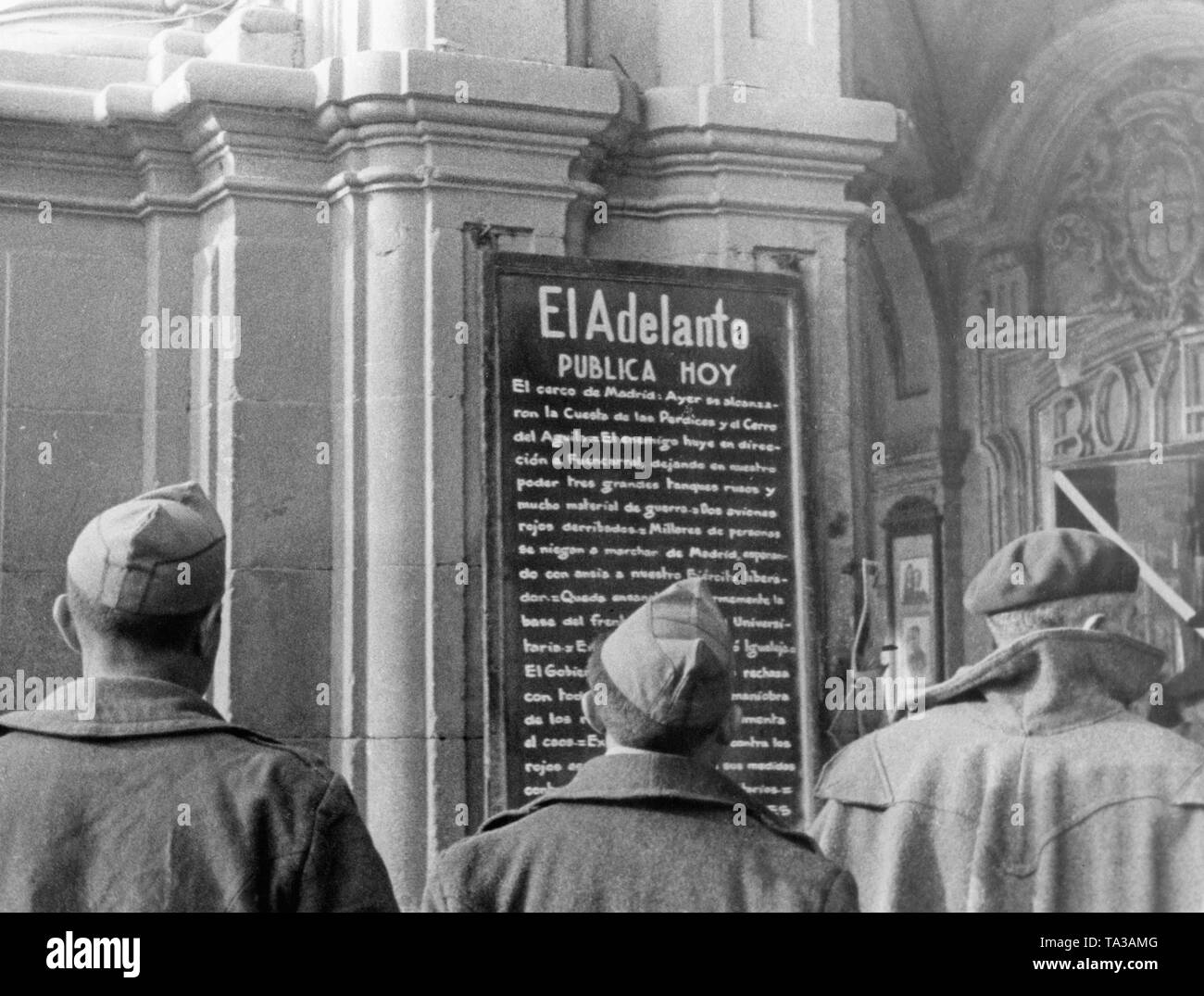 Photo of three Spanish soldiers, who are standing in front of a plaque of the El Adelanto de Salamanca newspaper  founded in 1883, where there were daily news published for the city (Publica Hoy). Stock Photo