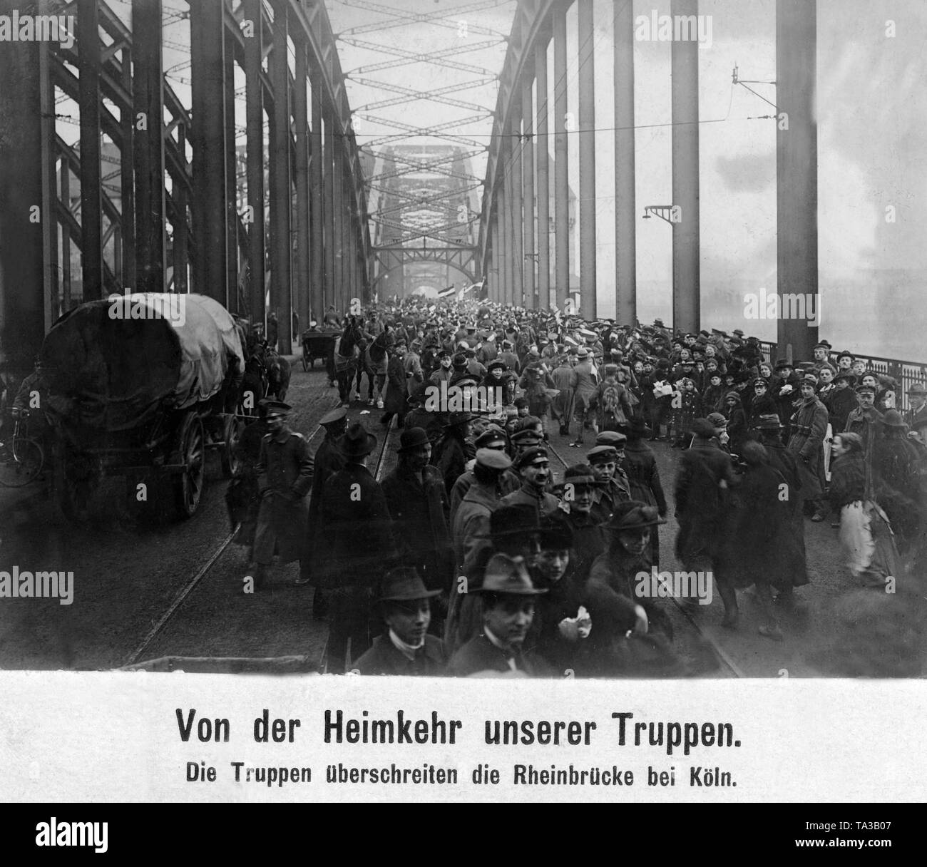 Returning soldiers are greeted by civilians on the bridge over the Rhine in Cologne. After the armistice agreement of Compiegne, the Left of Rhine region became a demilitarized zone. Stock Photo