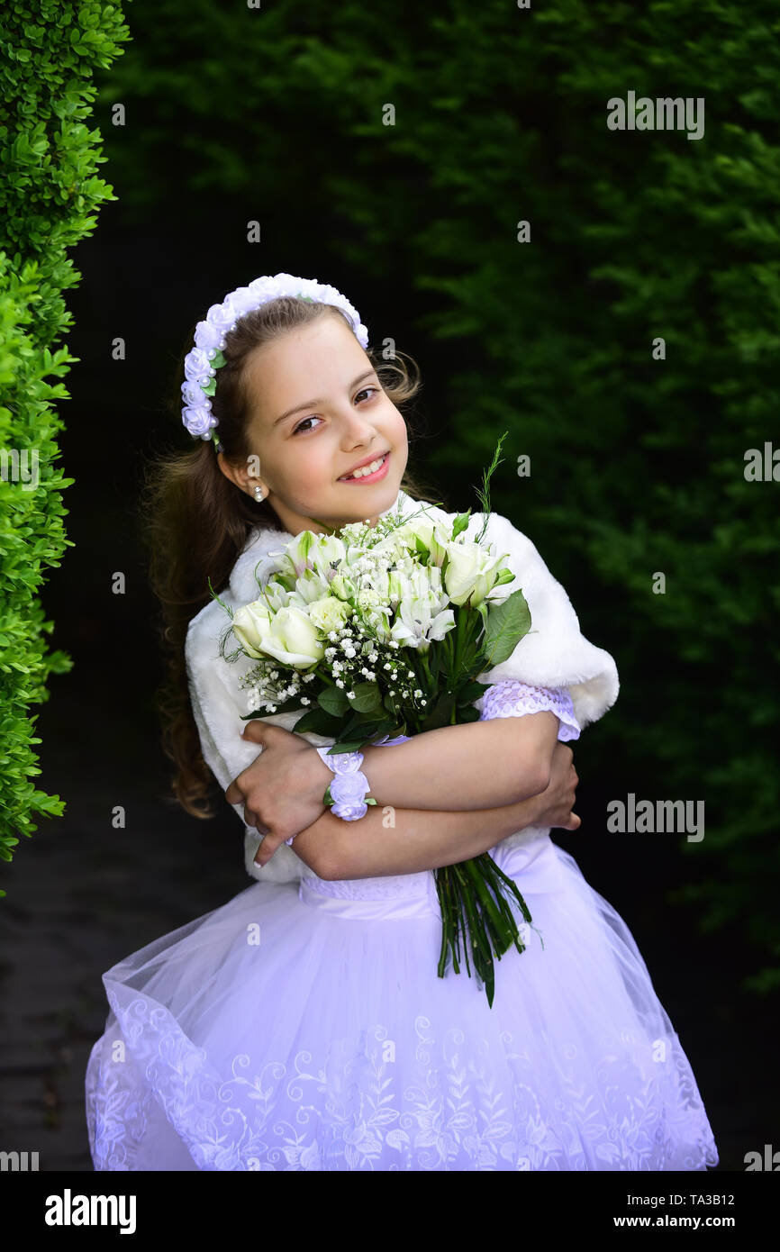 Little girl in white dress with rose flower bouquet Stock Photo - Alamy