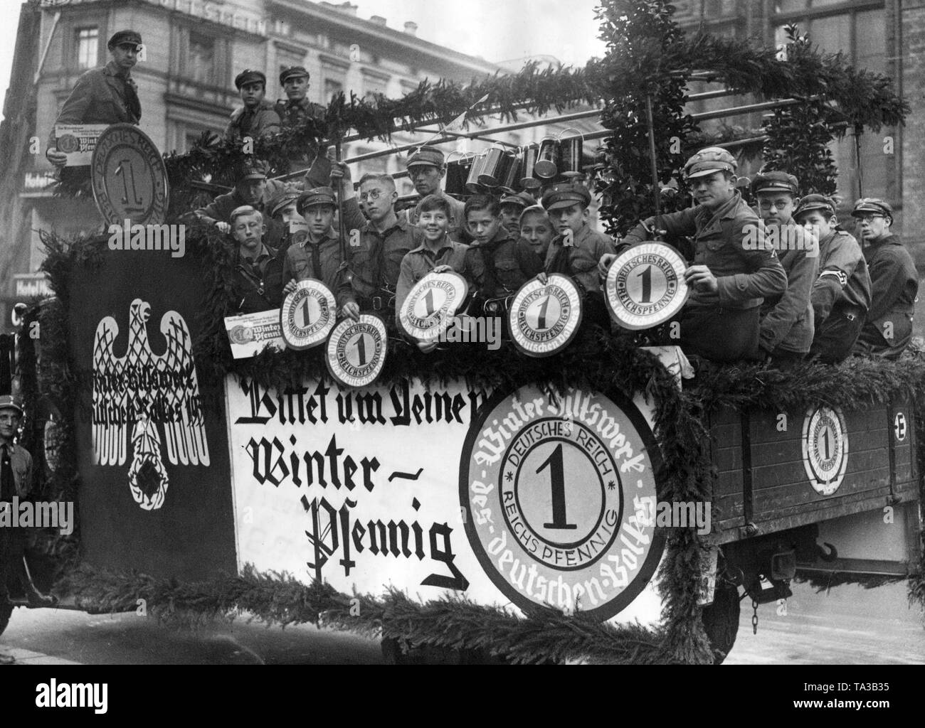 Members of the HJ on a decorated vehicle for the collection of the so-called Winterpfennig for the WHW. Stock Photo
