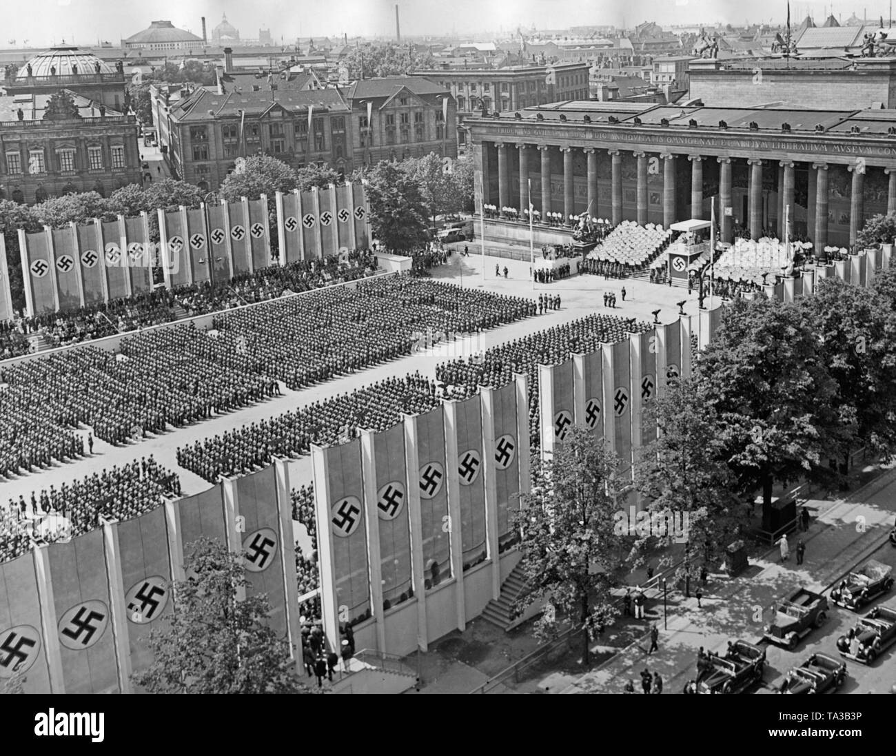 Photo of the fighters of the Condor Legion, who have stepped up in the Lustgarten after the parade, during the speech of Adolf Hitler (under a canopy with swastika) in front of the Altes Museum in Mitte (Berlin) on the 6th of June, 1939. On the right and on the left there are grand stands. On the stairs next to the lectern, members of the Hitler Youth are standing with signs depicting the names of the fallen legionaries in Spain. Stock Photo