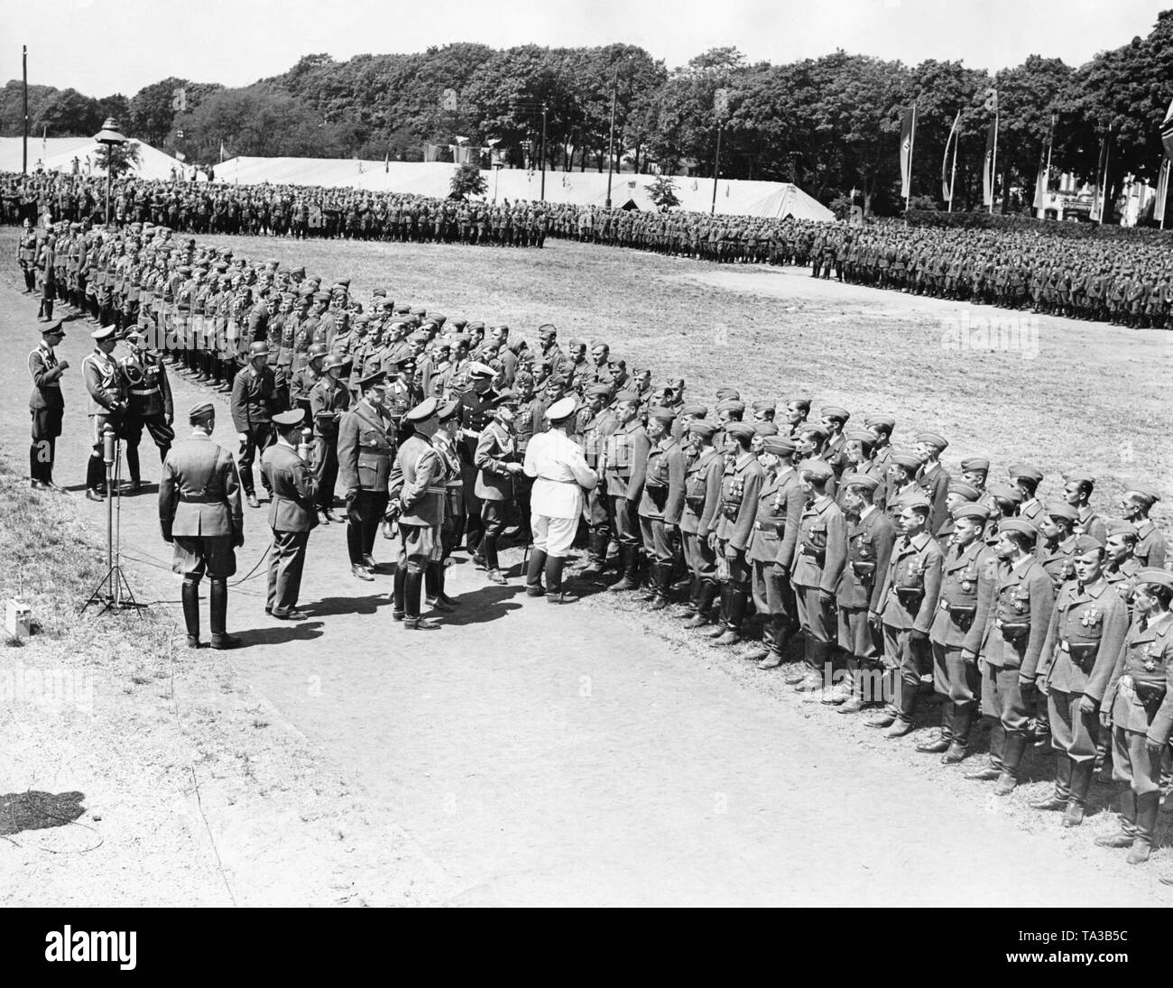 Together with other high-ranking members of the military, Field Marshal General Hermann Goering (in a white uniform) awards corporals and officers of the Condor Legion the Spanish Golden Cross in Doeberitz near Berlin on the 5th of June, 1939. Stock Photo