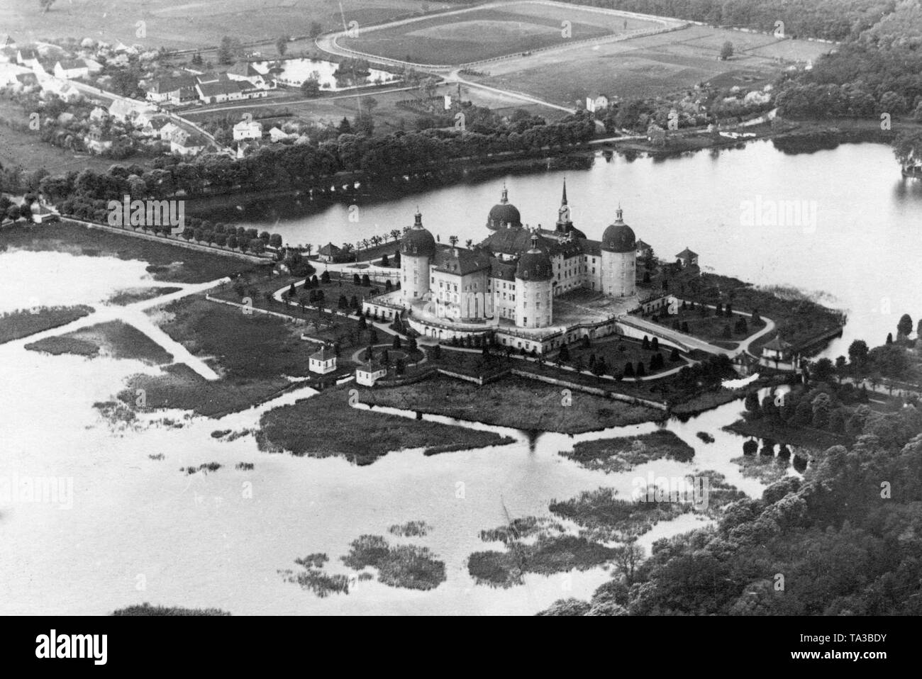 Aerial view of the Moritzburg hunting castle in Moritzburg near Dresden, Saxony. King August the Strong of Saxony started the construction of the Baroque complex in 1703 on an artificial island. The terraced area can be accessed via two bridges and is surrounded by eight guard houses with small port facilities. Stock Photo