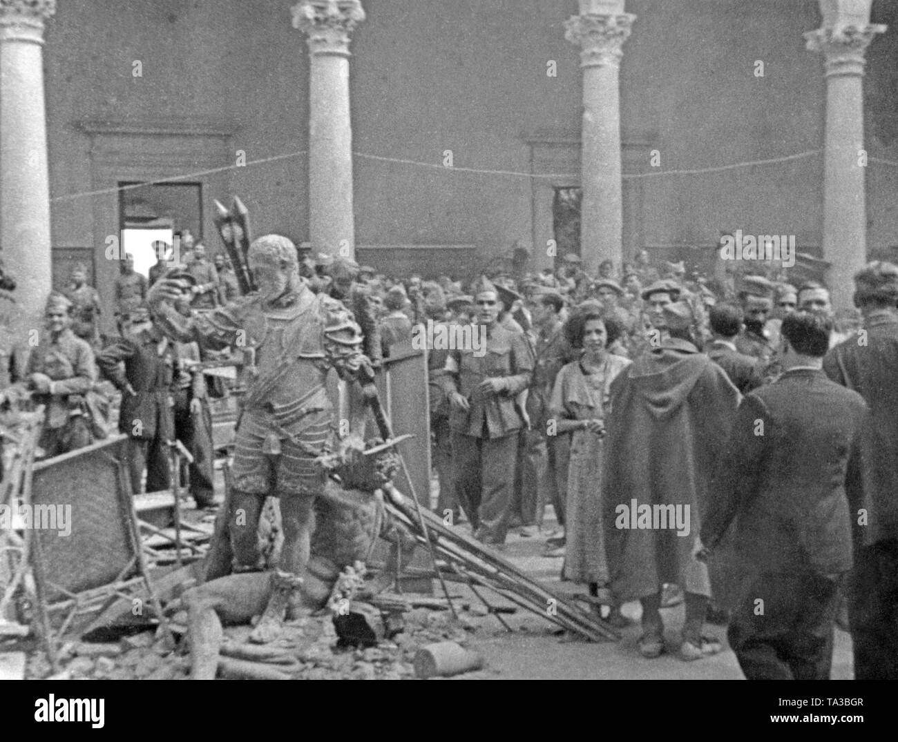 Spanish soldiers visit the patio of the liberated Alcazar of Toledo after its conquest on September 26, 1936. Below, the backside of the statue of King Charles V (Carlos V, Habsburg, 1500 to 1558). Stock Photo