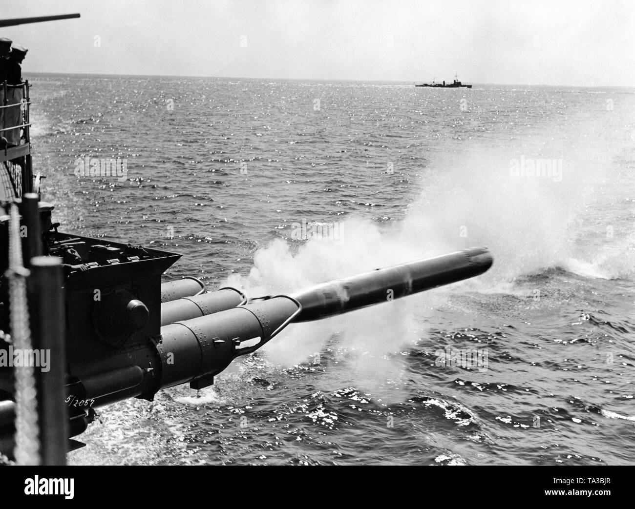 A war ship of the Kriegsmarine fires a torpedo, in the background one can recognize another ship. It is probably a filmstill. Stock Photo
