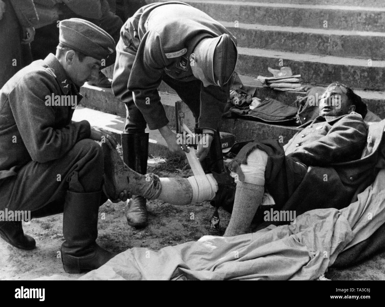 Members of a Flak unit bandage a French prisoner. Stock Photo