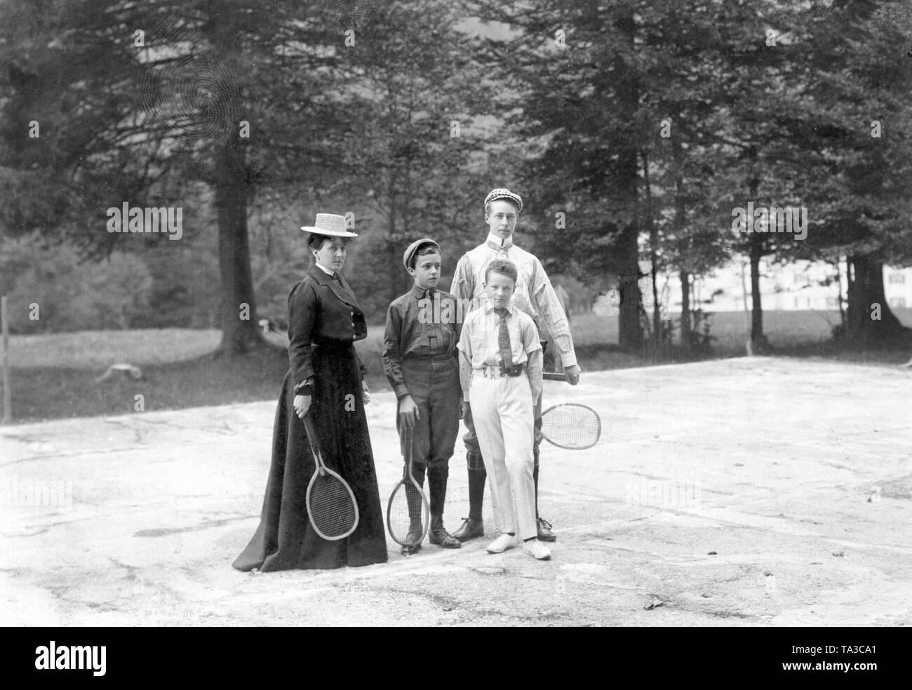 Crown Prince Wilhelm with members of the Bavarian royal family playing tennis. From left to right: Duchess Maria Jose in Bavaria (wife of Duke Karl Theodor in Bavaria, b. Princess of Portugal), her son Franz Josef in Bavaria, his cousin Luitpold in Bavaria and Crown Prince Wilhelm of Prussia. Stock Photo