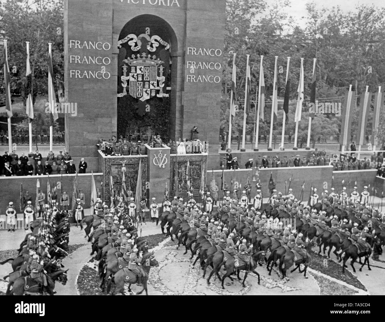 A mounted unit of the palace guards in old uniforms during the march past before General Francisco Franco on 19 May 1939 in Madrid. The General greets with the Fascist salute. Stock Photo