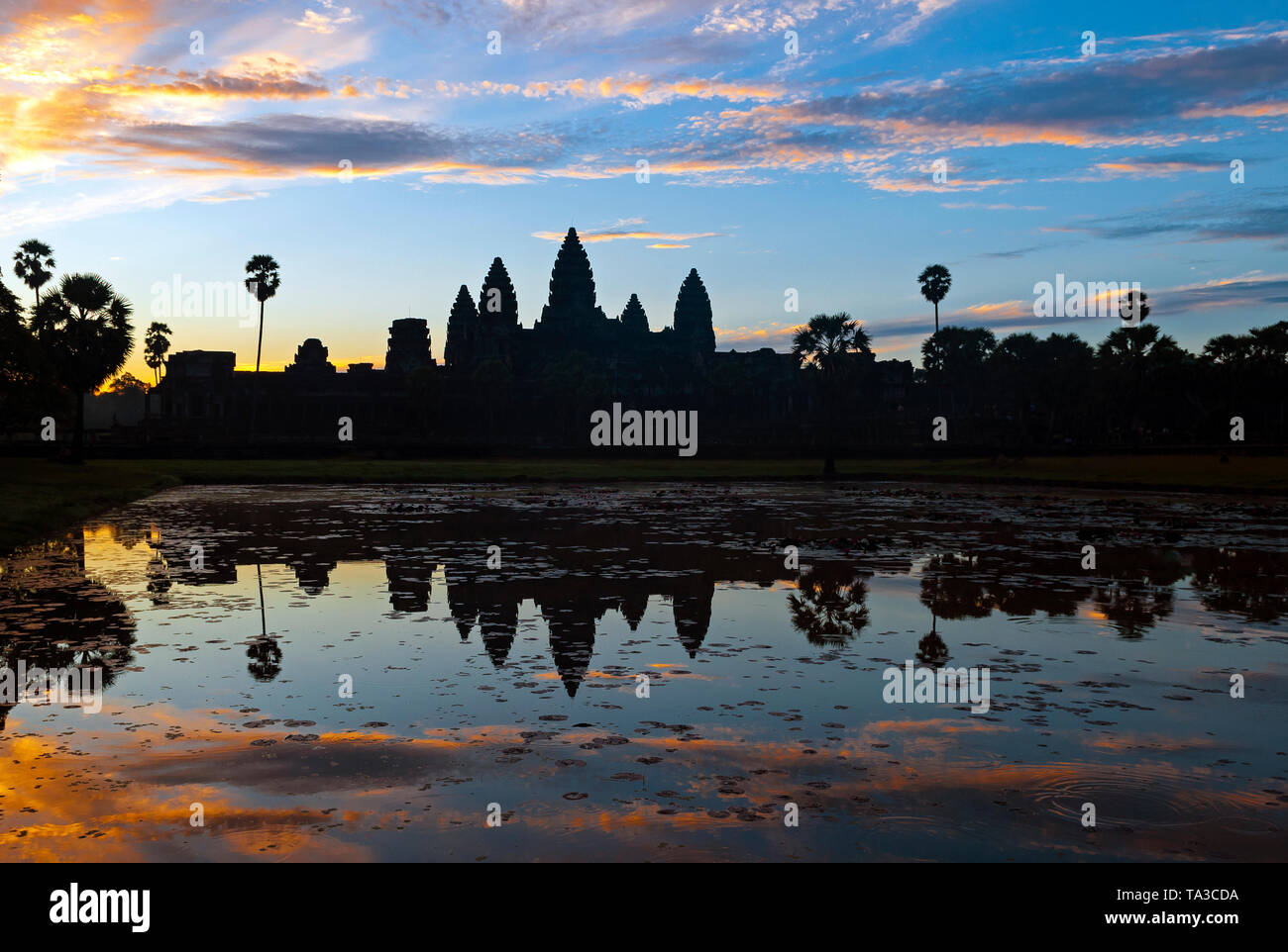 Colourful sunrise reflection in Angkor Wat with the silhouette of the temple towers with khmer architecture style, Siem Reap Province, Cambodia. Stock Photo