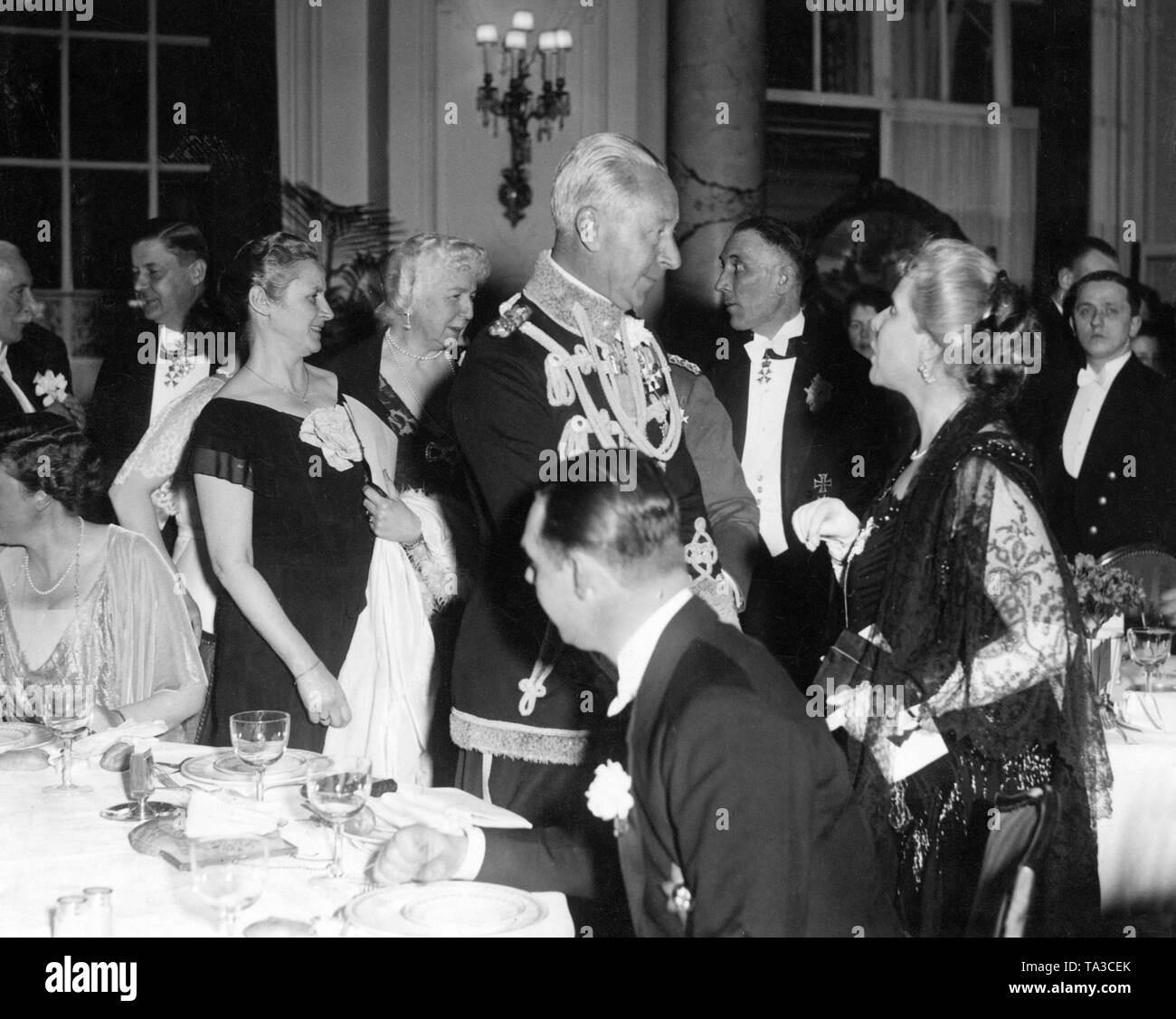 Crown Prince Wilhelm (standing, in uniform) on a festive event of Cecilienhilfe. It was probably a charitable organization of his wife Crown Princess Cecilie, born Duchess of Mecklenburg. Stock Photo