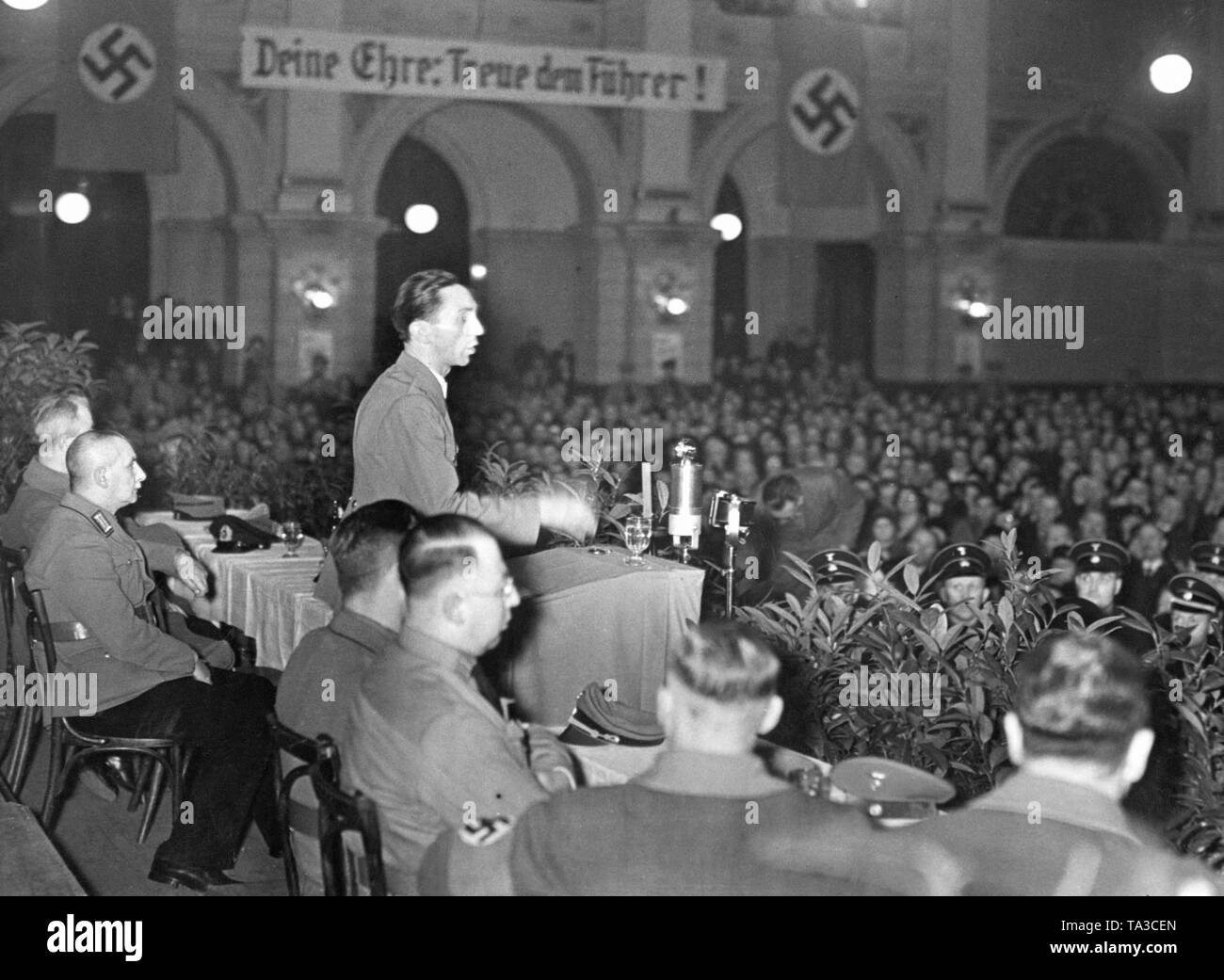 Joseph Goebbels speaks at a National Socialist demonstration. In the background, a banner 'Deine Ehre: Treue dem Fuehrer!' ('Your Honor: Be Faithful to the Leader!'), a demand for loyalty to Adolf Hitler. Stock Photo