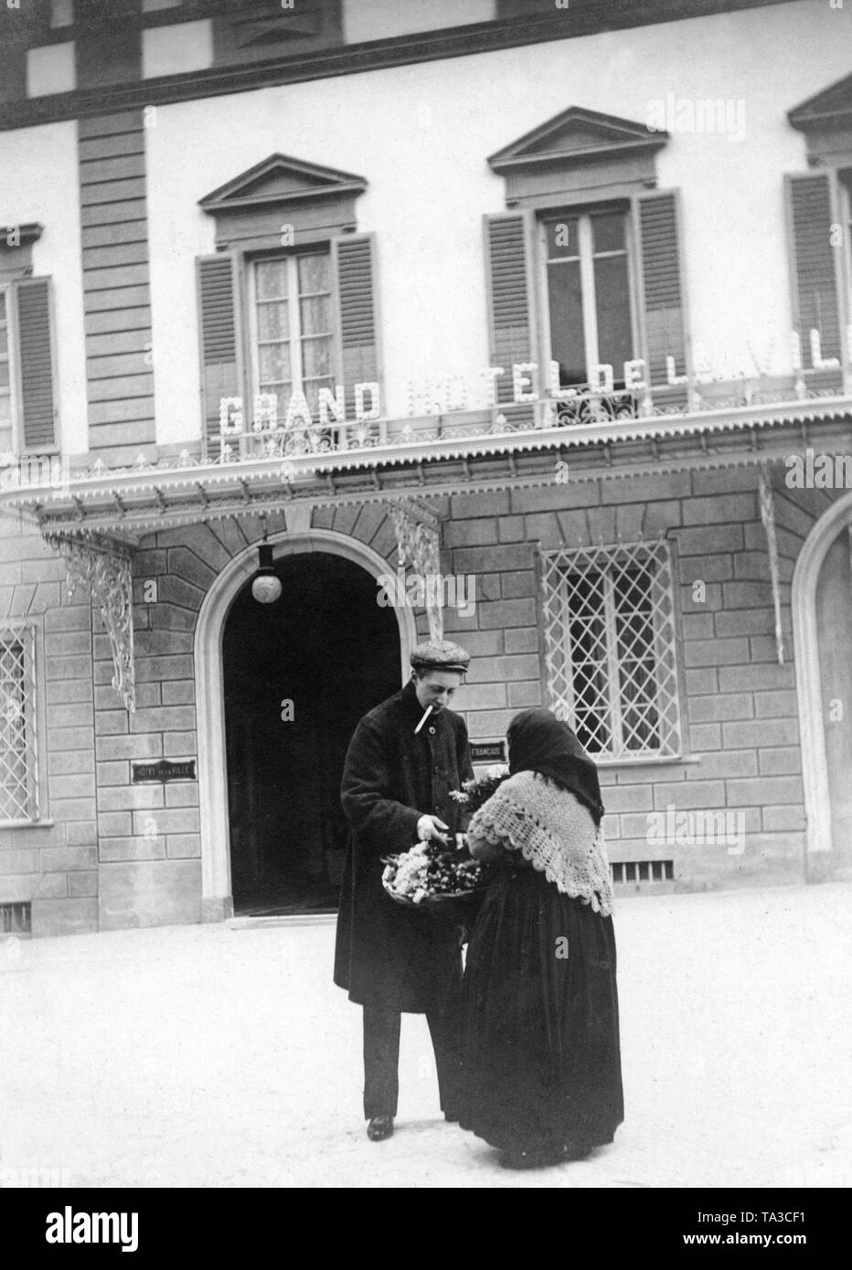 Crown Prince Wilhelm of Prussia buys a bunch of flowers from a street vendor in front of the Grand Hotel Villa Medici. Stock Photo