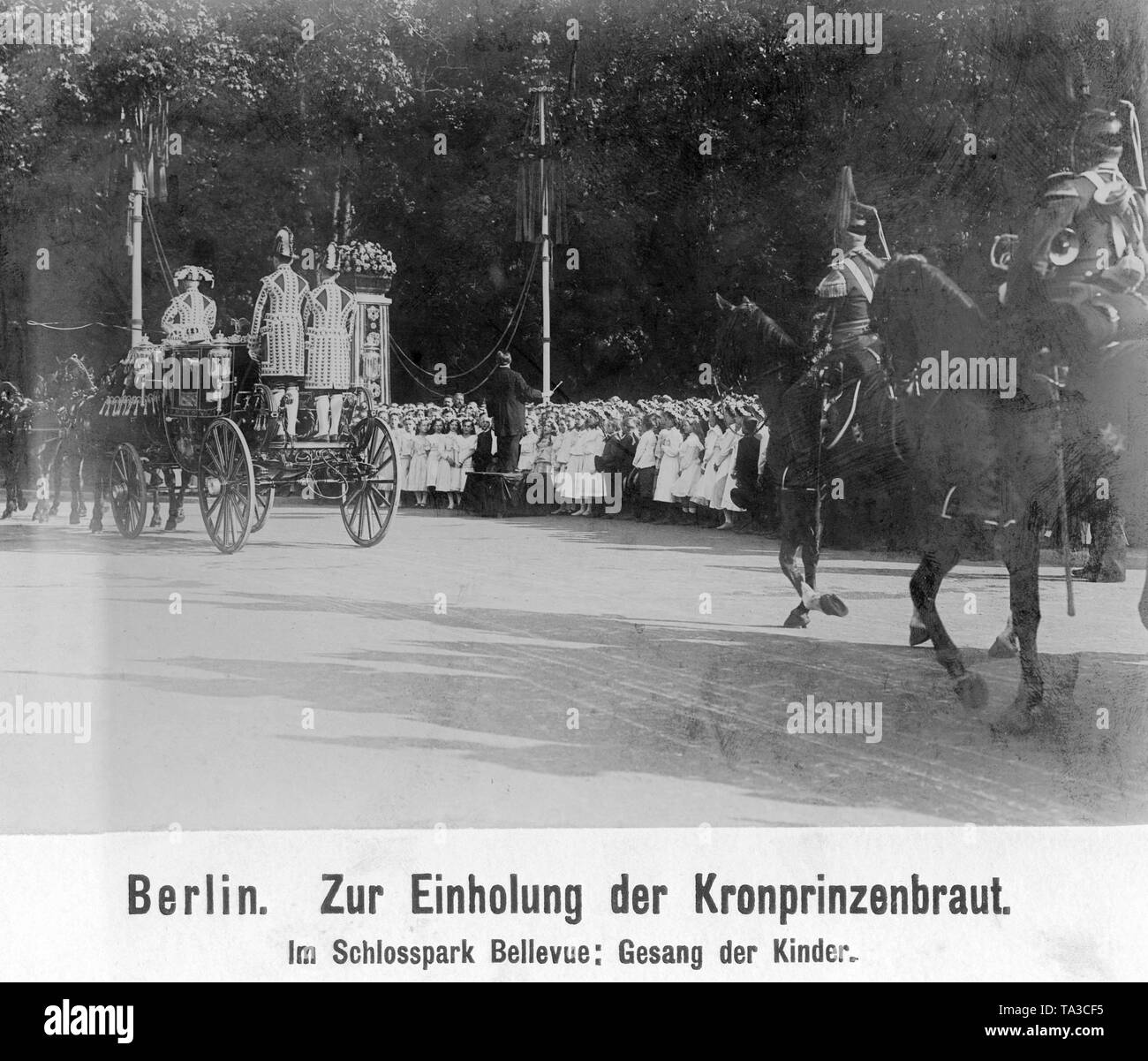 As part of the wedding celebrations lasting several days, the bride, Princess Cecilie of Mecklenburg, was solemnly taken to the Potsdam City Palace. Here her carriage passes Bellevue Palace, where a children's choir has set up to serenade the future Prussian Crown Princess. Stock Photo