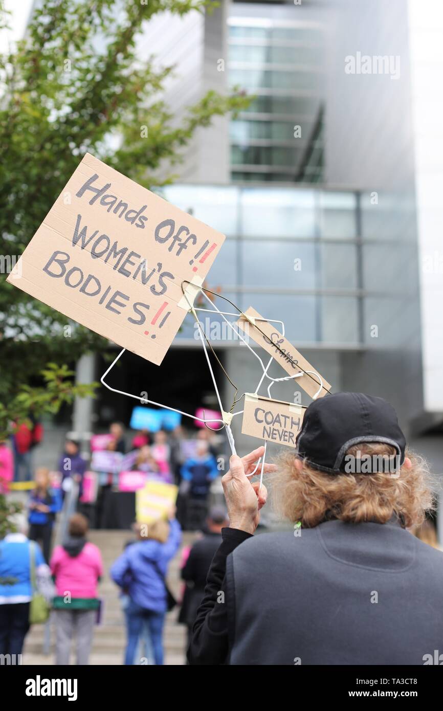 A woman holding a coat hanger sign at a protest against abortion bans, Eugene, Oregon, USA. Stock Photo