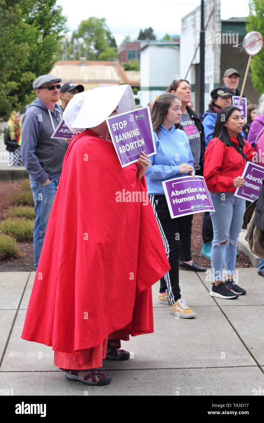 A woman dressed in a handmaid's tail costume at a protest against abortion bans, Eugene, Oregon, USA. Stock Photo