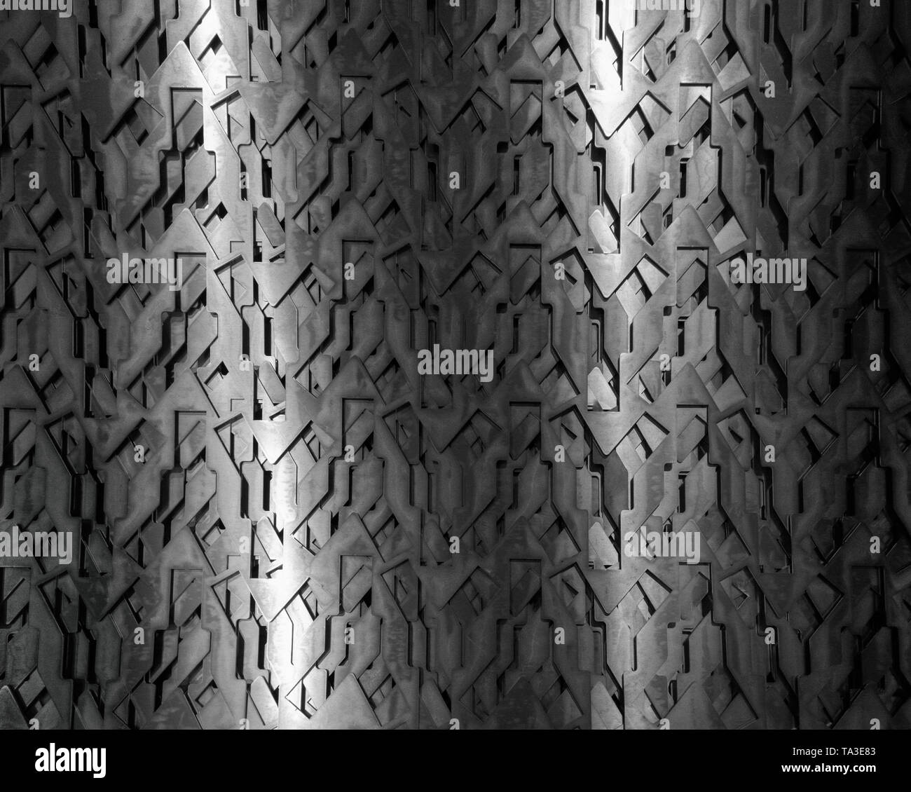 Light glow on grill pattern. Dark grainy industrial abstract background. Stock Photo