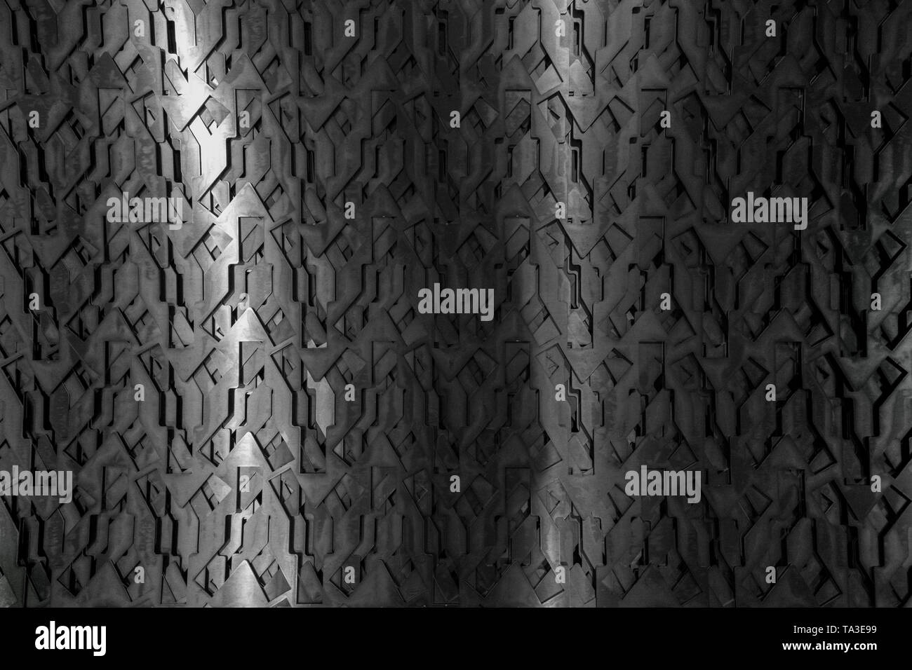 Light glow on grill pattern. Dark grainy industrial abstract background. Stock Photo