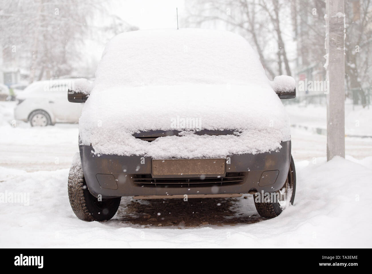 Old dirty car covered by thick snow layer with selective focus Stock Photo