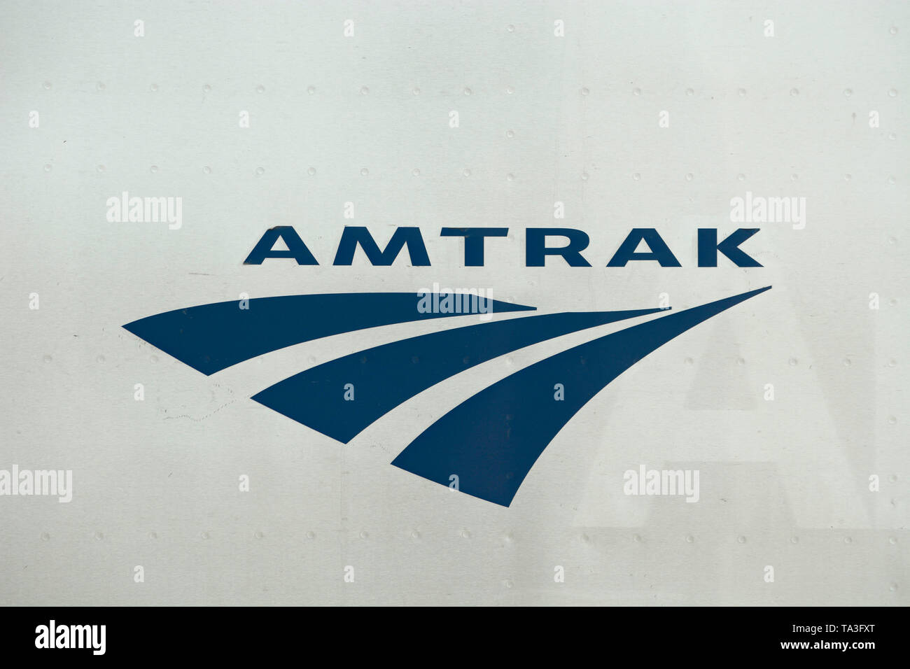 The Amtrak logo on the side of a passenger coach stopped to pick up passengers at the historic train depot and Amtrak stop in Lamy, New Mexico, USA. Stock Photo