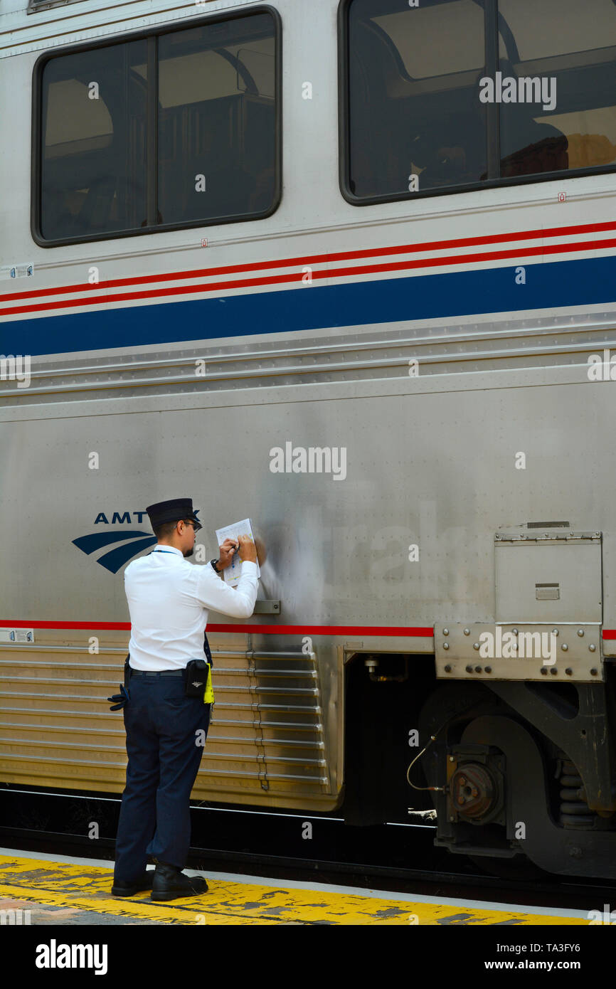 An Amtrak conductor completes paper work after picking up passengers at the train depot and Amtrak stop in Lamy, New Mexico USA Stock Photo