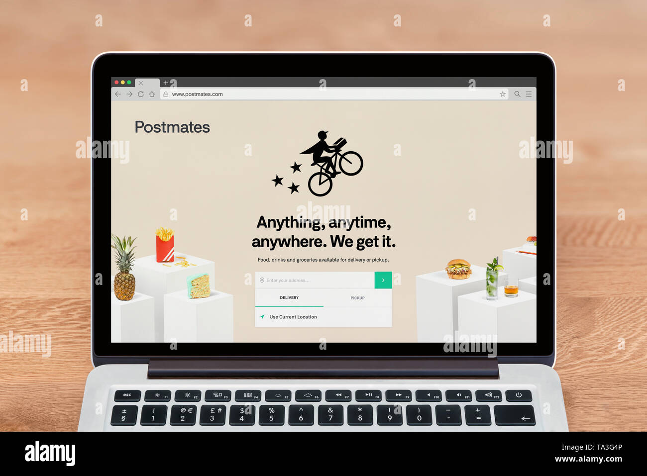 An Apple Macbook displays the Postmates website (Editorial use only). Stock Photo