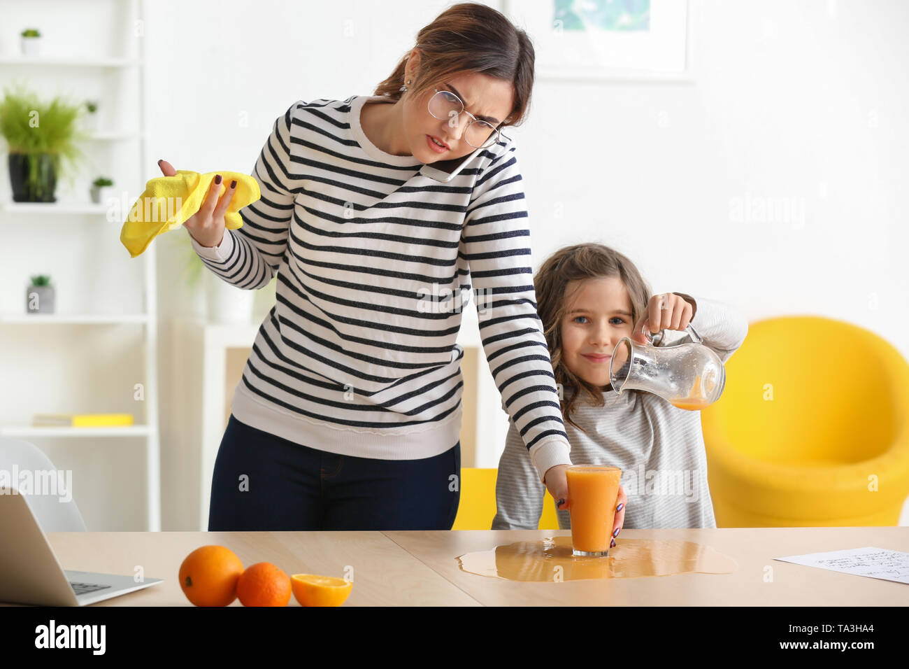 Busy mother with naughty daughter working at home Stock Photo - Alamy