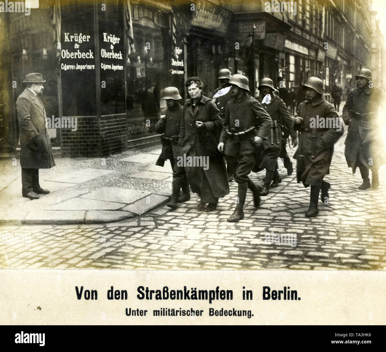 During the Berlin Maerzkaempfe (March fights) Freikorps units take a woman into custody, who apparently belongs to the insurgents. The location of the picture is probably the Richard-Sorge-Strasse (former Tilsiterstrasse) in the district of Friedrichshein. Stock Photo