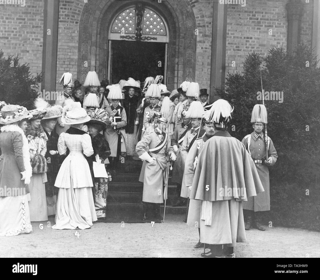 The imperial family after the confirmation of Prince Friedrich Sigismund of Prussia in front of the Peace Church in Potsdam. On the picture: Prince Friedrich Sigismund (on the stairs, 3rd man from left with book under his arm), Prince Friedrich Karl (right next to Sigismund), Crown Prince Wilhelm (standing in front of Friedrich Karl at the foot of the stairs with saber in the hand), Prince August Wilhelm (diagonally right in front of Crown Prince Wilhelm, facing the viewer) in conversation with Emperor Wilhelm II (standing with his back to the viewer). On the right side of the picture stands Stock Photo