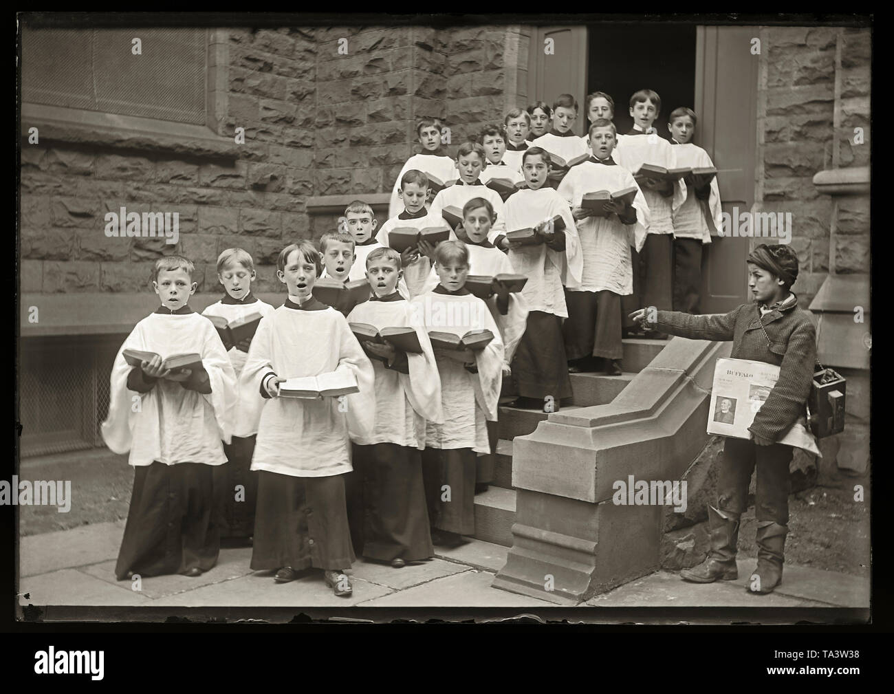 1890s Buffalo, NY Newspaper boy pointing at local boys choir. Photo from 5x7 inch glass negative. Stock Photo