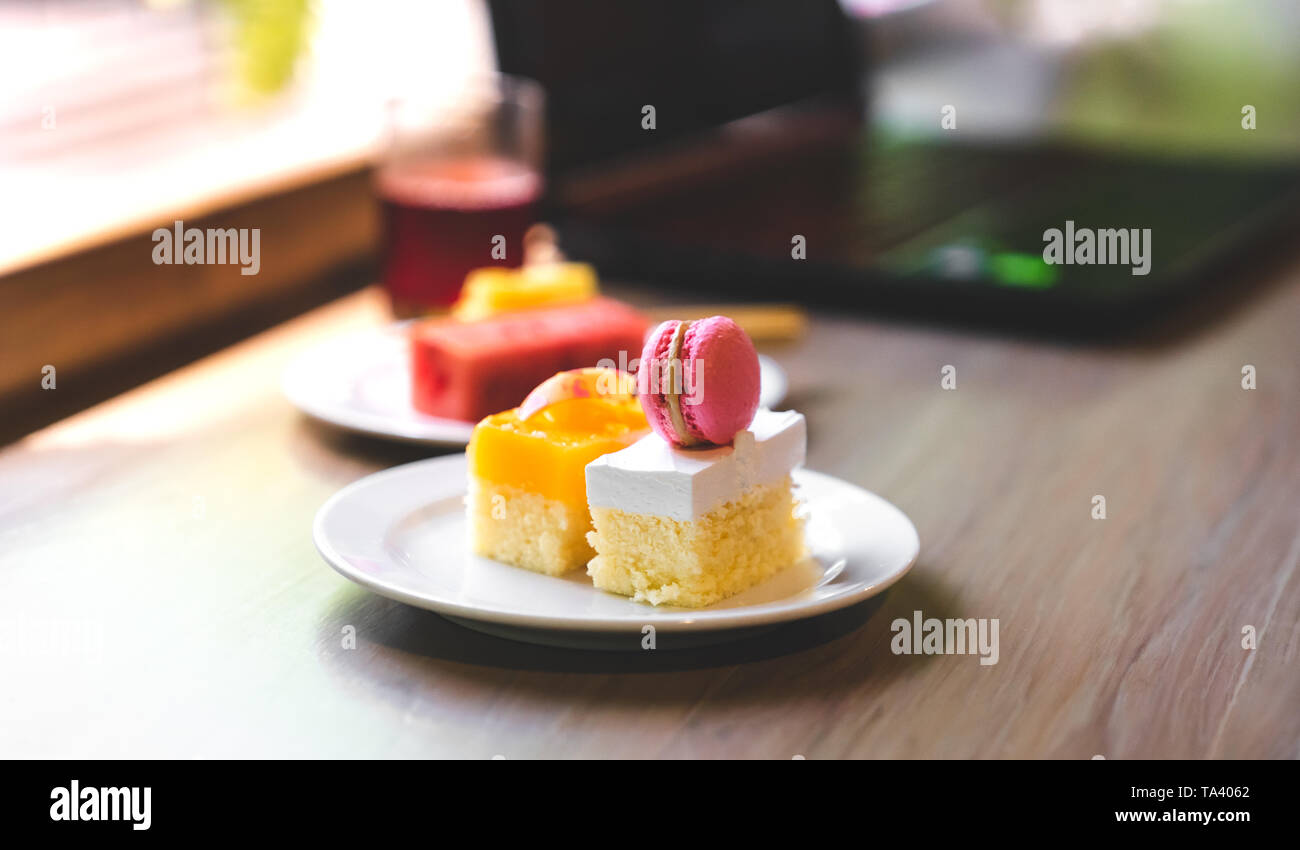 sweet cake on desk with laptop in background, copy space Stock Photo