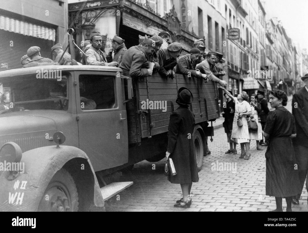 A truck with French soldiers in the Rue des Martyrs in Paris. The soldiers are driven in a German lorry through Paris, which stops here, so that Parisians can supply their compatriots. Stock Photo