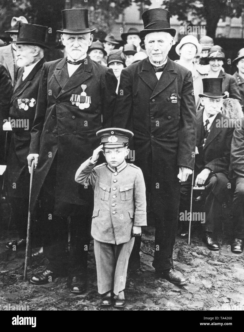Veterans from the Franco-Prussian War and World War I arrived to Potsdam for a meeting. Many took their sons and grandchildren with them, who, just as this little boy, appeared in re-made Reichswehr uniforms. Stock Photo