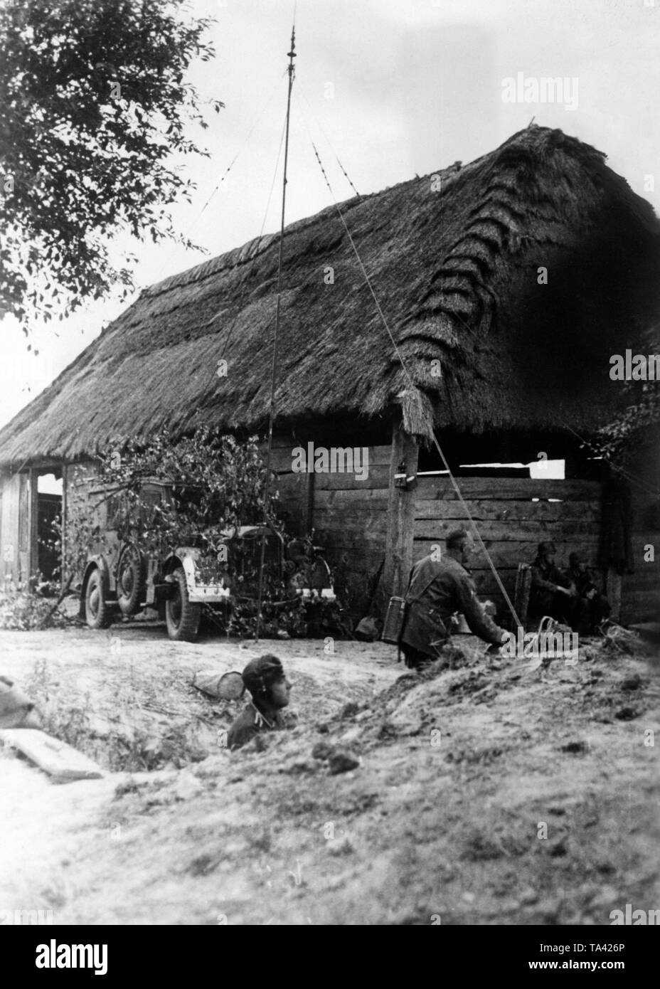 A camouflaged radio van of the Wehrmacht, assigned to Army Group Center, in front of a wooden hut in the area of the border river Bug, which the Wehrmacht crossed on 22 June 1941. The radio car receives and delivers information from and for reconnaissance pilots. Photo: war reporter Veitel. Stock Photo