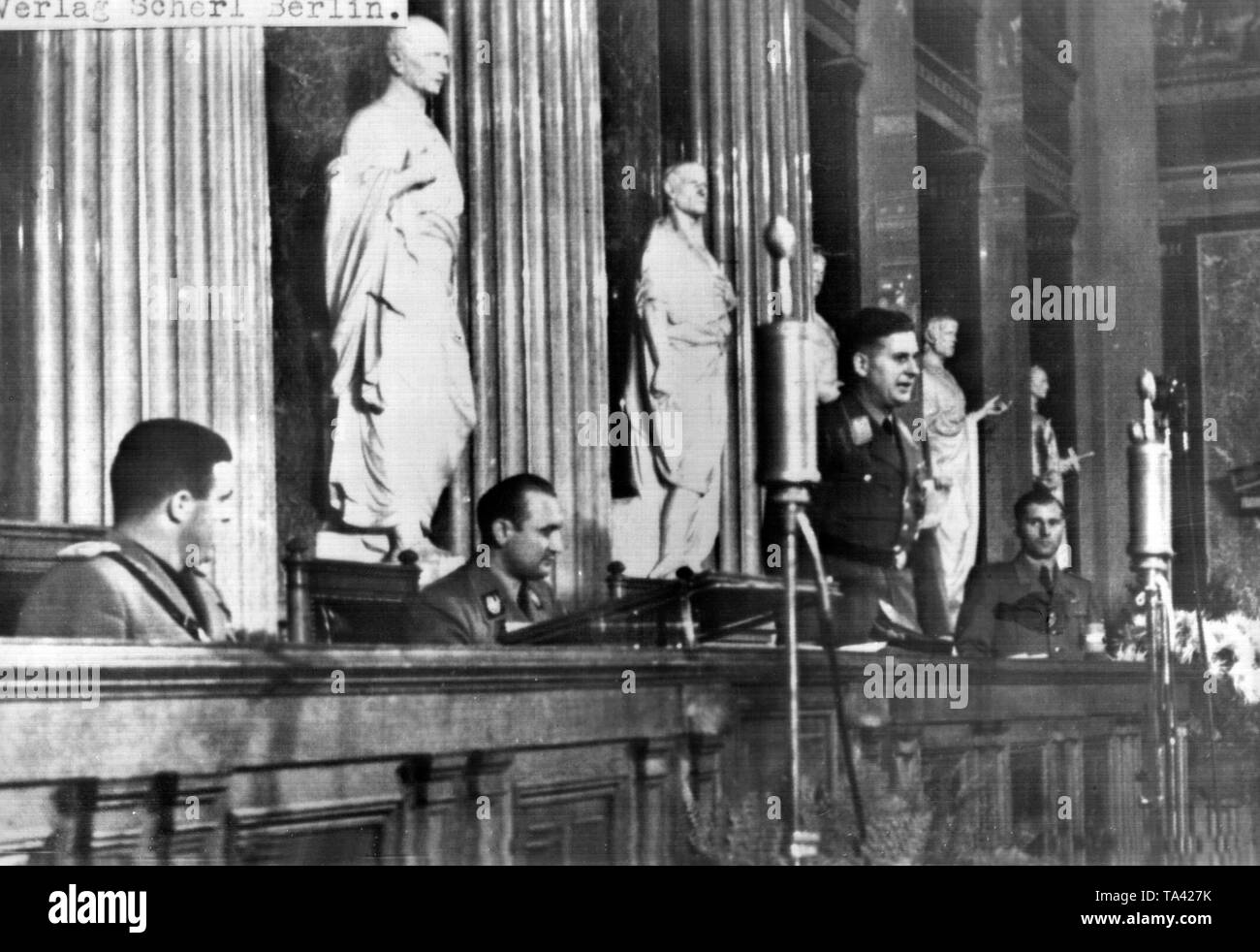 Baldur von Schirach (middle, standing) gives a speech at the founding ceremony of the European Youth Organization in the Gauhaus in Vienna. To his left Artur Axmann and the leader of the 'Gil', minister of the Italian Youth Organization Aldo Vidussoni. Stock Photo
