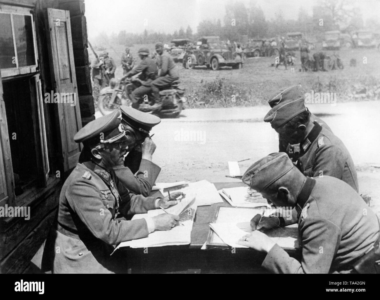 Officers and generals of the Wehrmacht in Lithuania during a briefing of the division command post. In the background dispatch riders and vehicles of the divison. Photo: war correspondent Zoll. Stock Photo