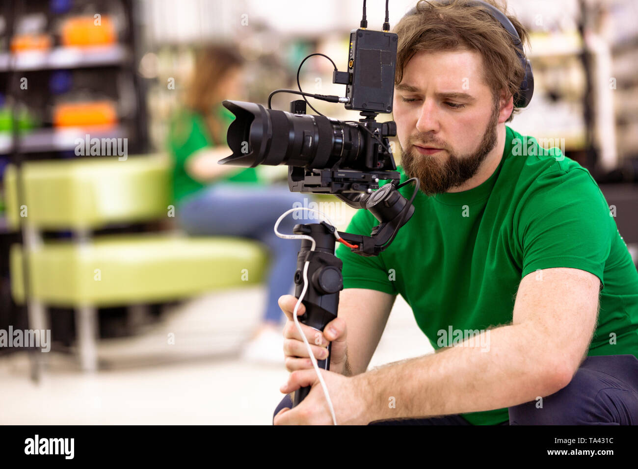 Videographer shooting a film or a television program in a studio with a ...