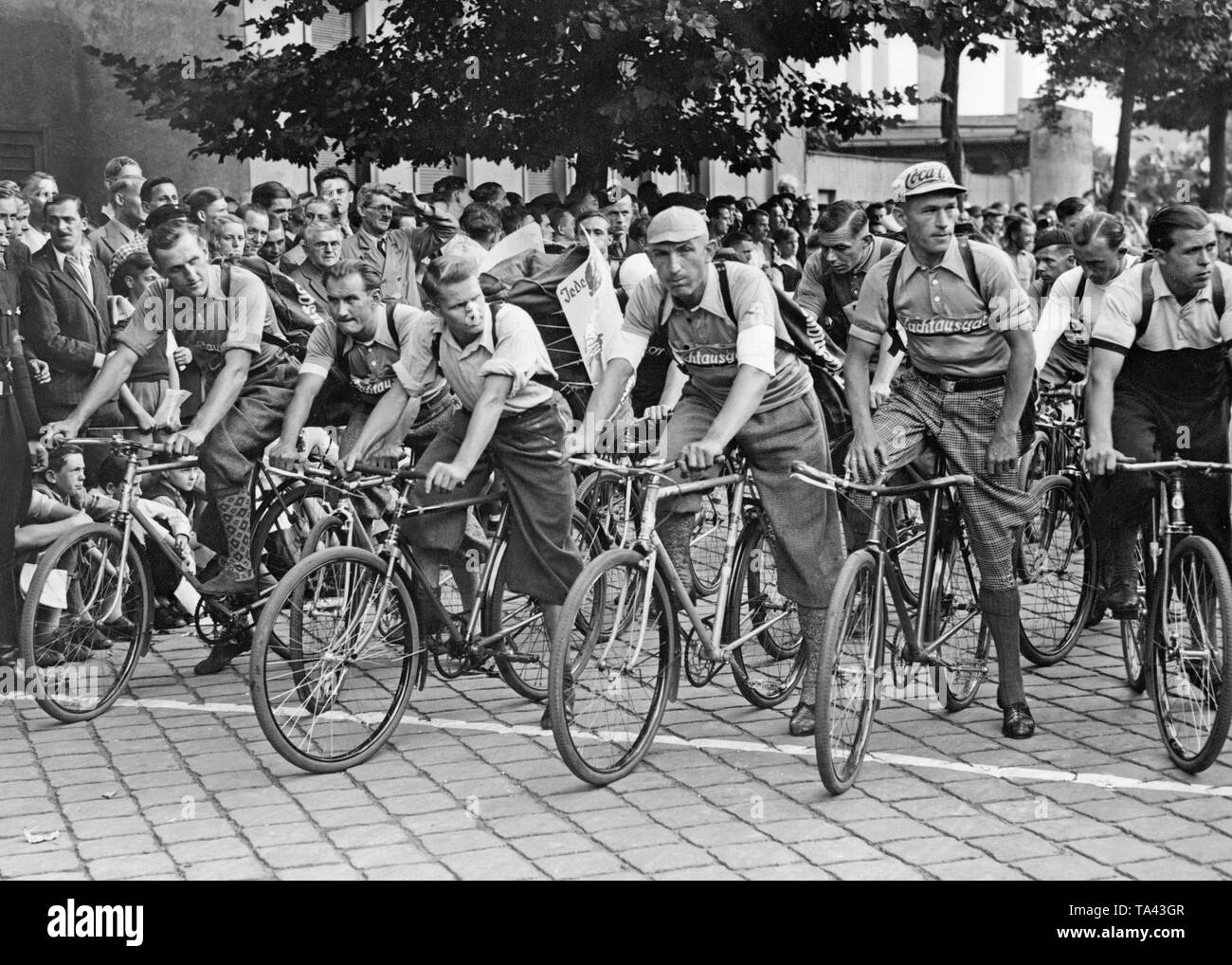 The participants of the Championship of Paperboys of Scherl are ready to start the race in the Siemensstrasse in Berlin-Moabit. They carry backpacks. Stock Photo