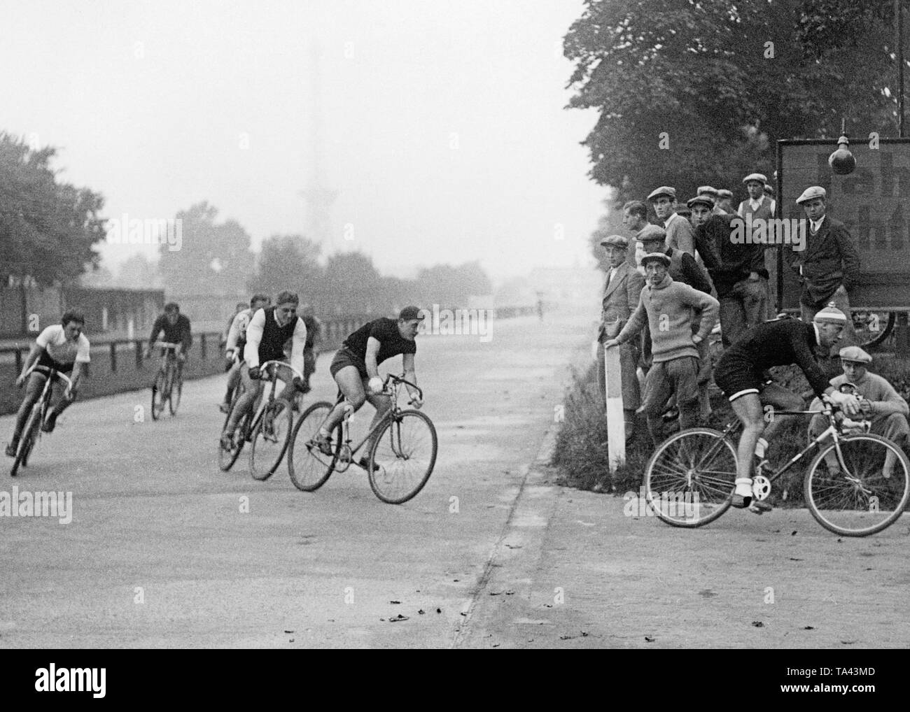 Participants of the cycling race for sports journalists in Berlin. In the background in the fog, the Berlin TV Tower. Stock Photo