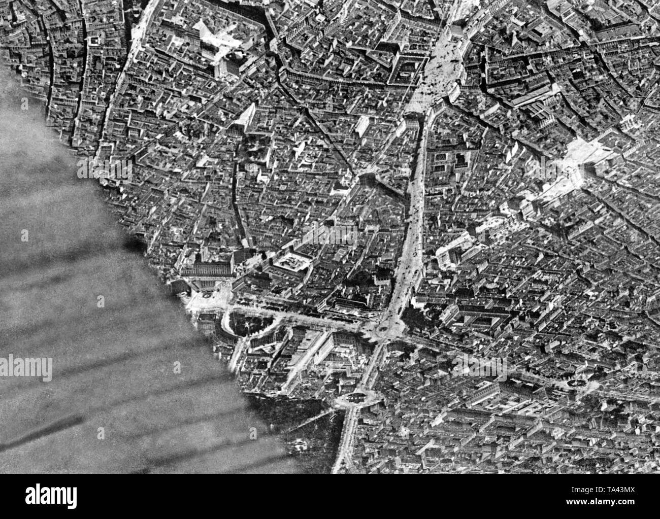 Aerial photo of the center of Madrid during the Spanish Civil War on November 9, 1936. Below in the center, the Puerta del Sol, right next to it, the Gran Via, which was still under construction. Above in the center, the Plaza de Cibeles with the Town Hall of Madrid (white, towers) and the Puerta de Alcala with the gate at the entrance to the Retiropark. To the left, the Plaza del Colon, on the right, the Plaza de la Lealtad with the Madrid Stock Exchange. Covered by the wing: the Prado. Stock Photo