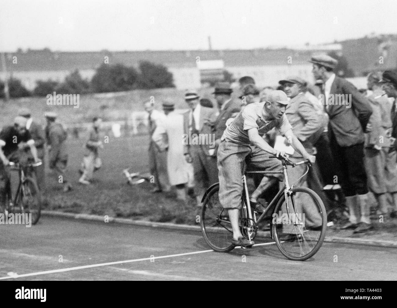 Participants of the cycle race of sports journalists ride through the Polizeistadion in Berlin. Stock Photo