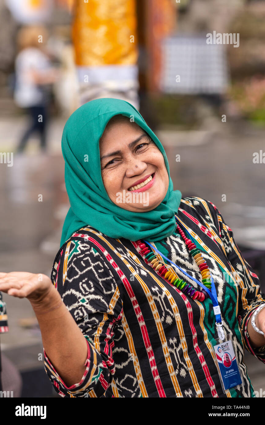 Bali, Indonesia - February 25, 2019: Ulun Danu Beratan Temple complex in Bedoegoel. Closeup of smiling head-covered Muslim woman. Stock Photo