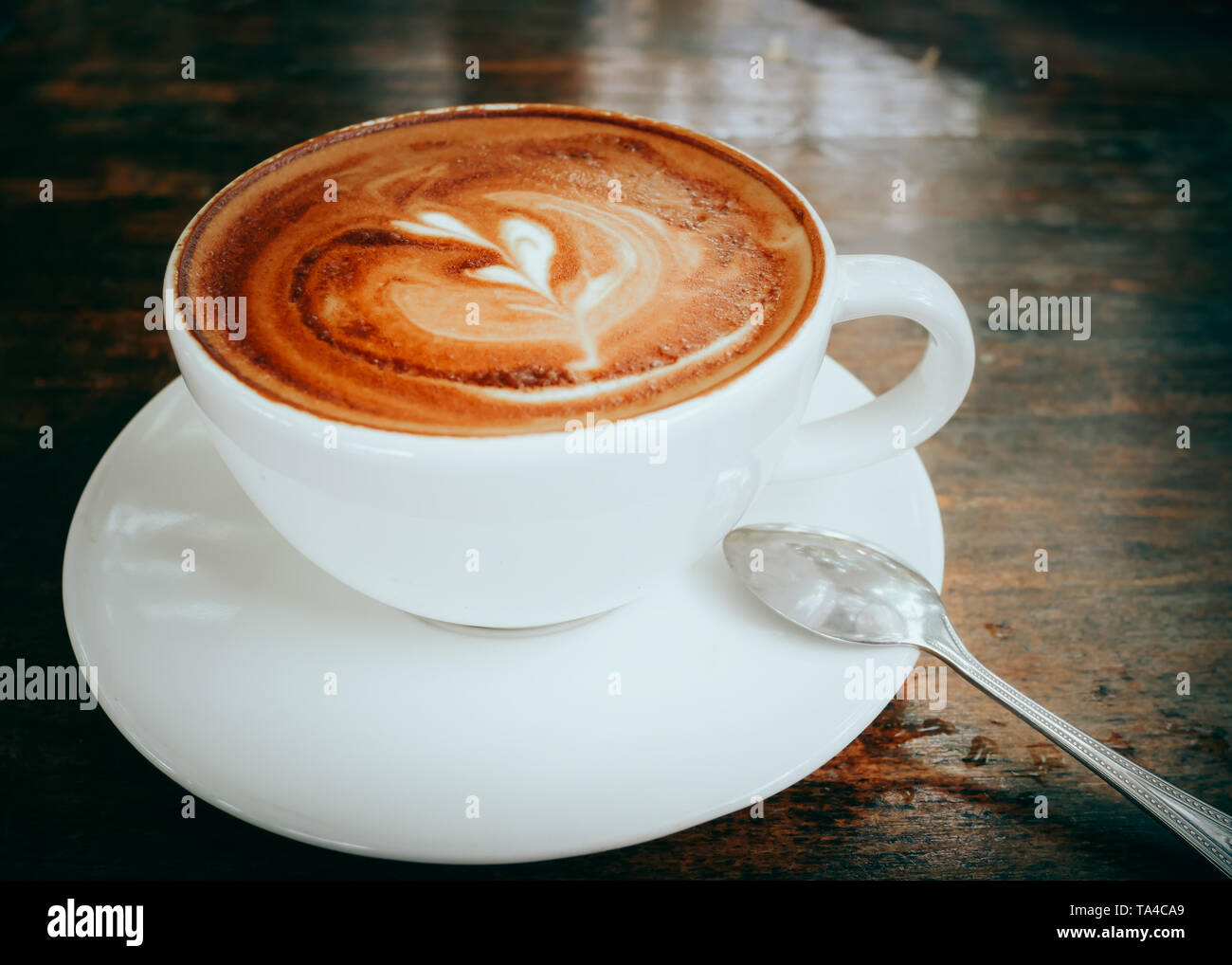 hot coffee latte art on wood table background close up. Stock Photo