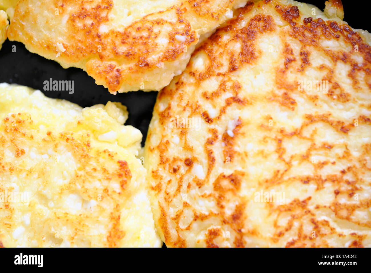 Close-up cheesecakes are cooked in a frying pan with vegetable oil, food background macro photo Stock Photo