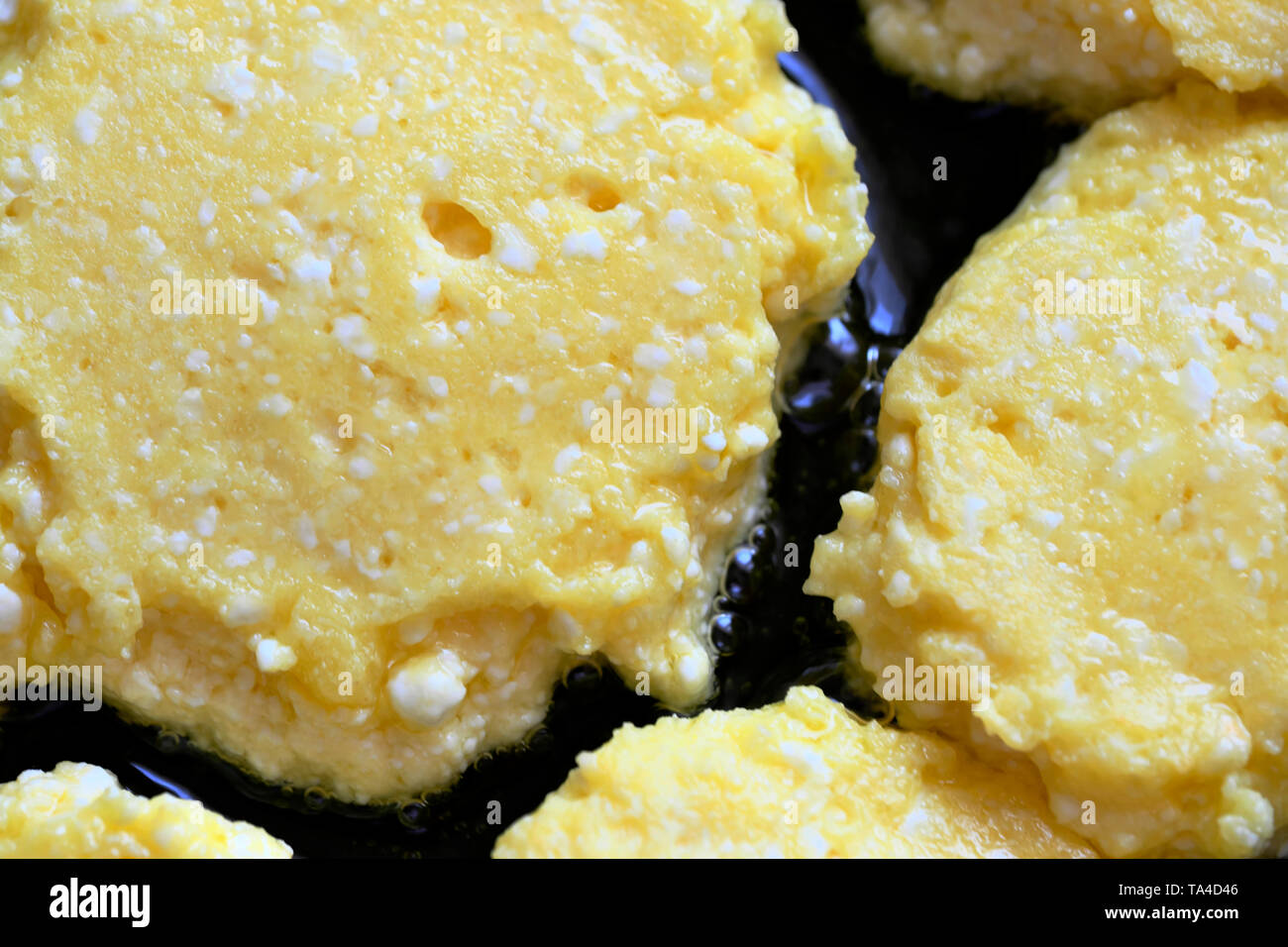 Close-up cheesecakes are cooked in a frying pan with vegetable oil, food background macro photo Stock Photo