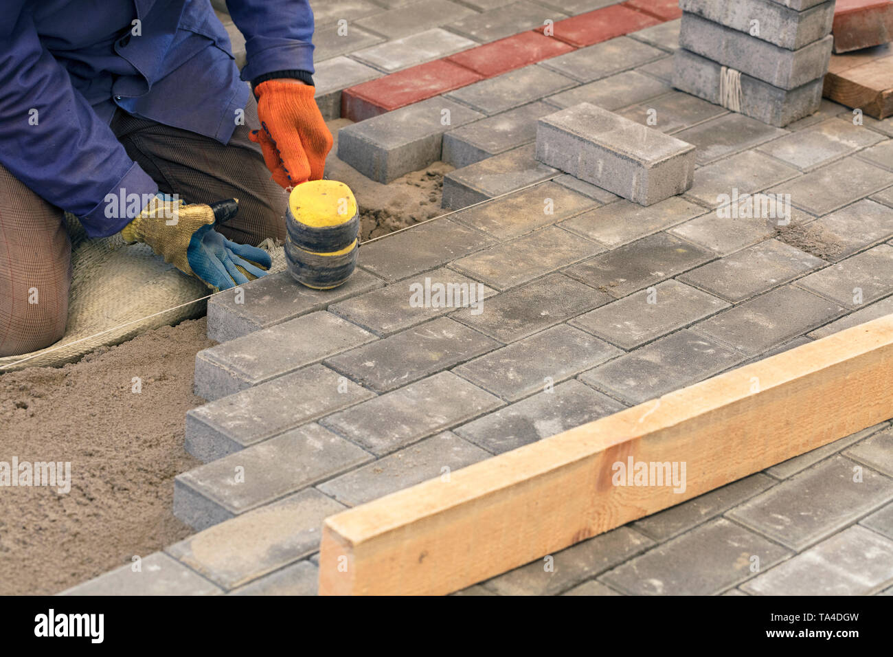 Paving Thread The worker lay the paving slab with special hammers, leveling it ...